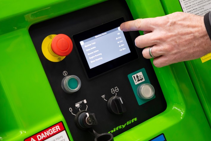 Operator using the HR12 4x4 onboard diagnostics touchscreen to view machine usage statistics